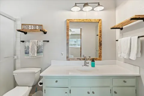 a bathroom with a sink mirror vanity and toilet
