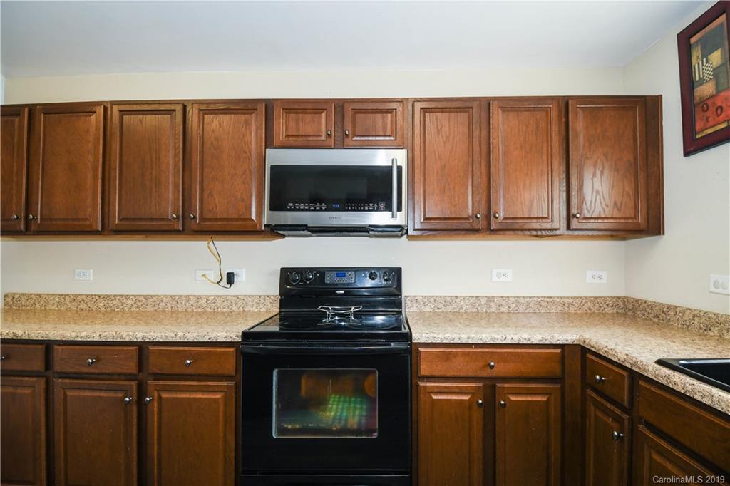 660 Potter Place Road Fort Mill, SC 29708 - Photo 9 of 23 a kitchen with granite countertop a stove top oven microwave and cabinets