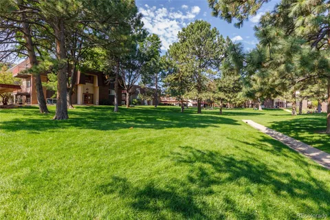 a backyard of a house with lots of green space and fountain