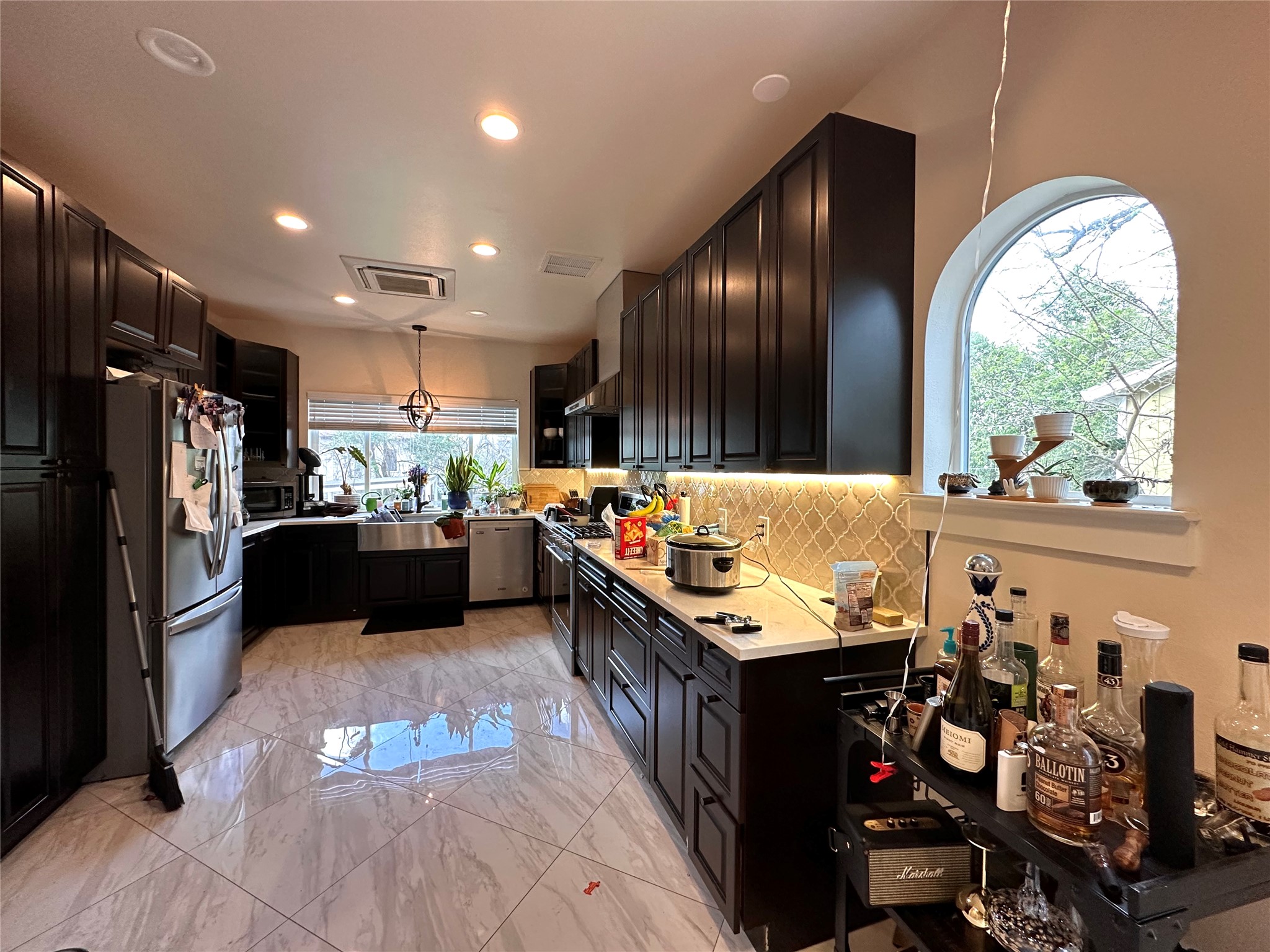5004 Rowena Avenue, Unit A Austin, TX 78751 - Photo 10 of 24 a kitchen with stainless steel appliances kitchen island granite countertop a refrigerator a sink dishwasher a stove and a dining table with wooden floor