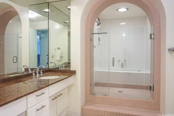 a bathroom with a granite countertop sink mirror and bathtub