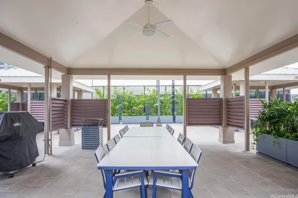 a patio with a table and chairs and potted plants