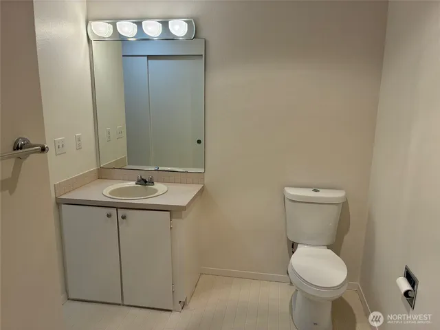 a bathroom with a toilet a sink and mirror