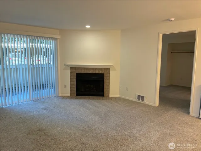 an empty room with fireplace and windows