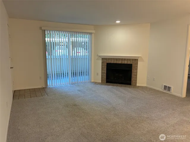 an empty room with entrance and fireplace