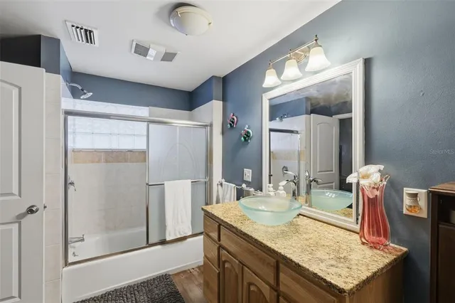 a bathroom with a granite countertop sink and a mirror
