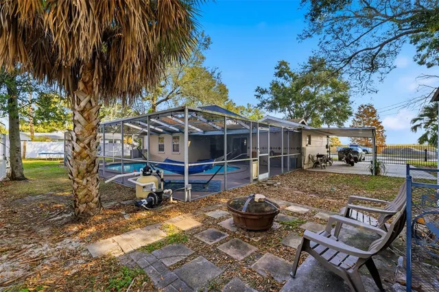 a view of house with backyard entertaining space and swimming pool