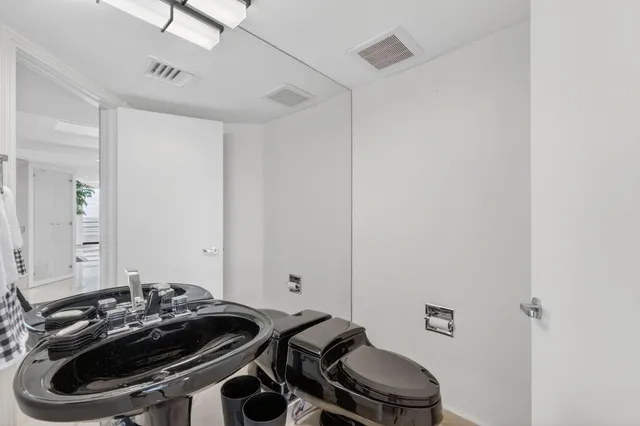 a living room with furniture a kitchen view and a large window
