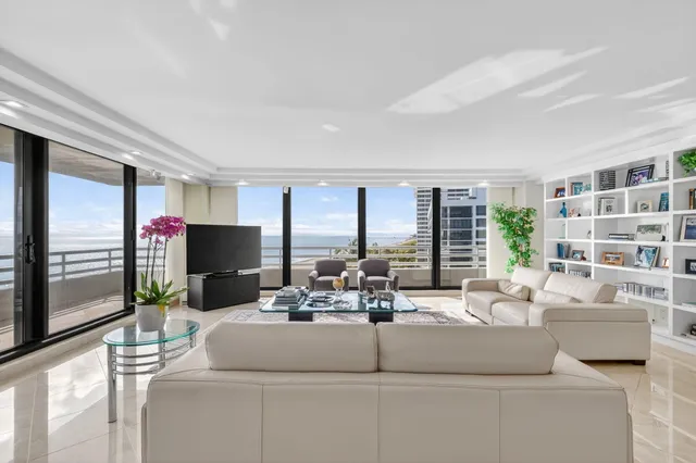 a living room with furniture kitchen view and a large window