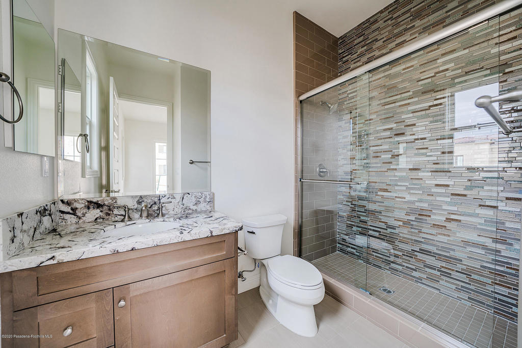20156 West Cromwell Way Porter Ranch, CA 91326 - Photo 14 of 39 a bathroom with a granite countertop toilet sink mirror and shower