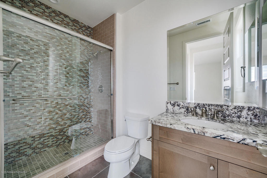 20156 West Cromwell Way Porter Ranch, CA 91326 - Photo 31 of 39 a bathroom with a granite countertop sink a toilet and shower