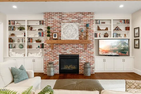 a living room with furniture a fireplace and a flat screen tv