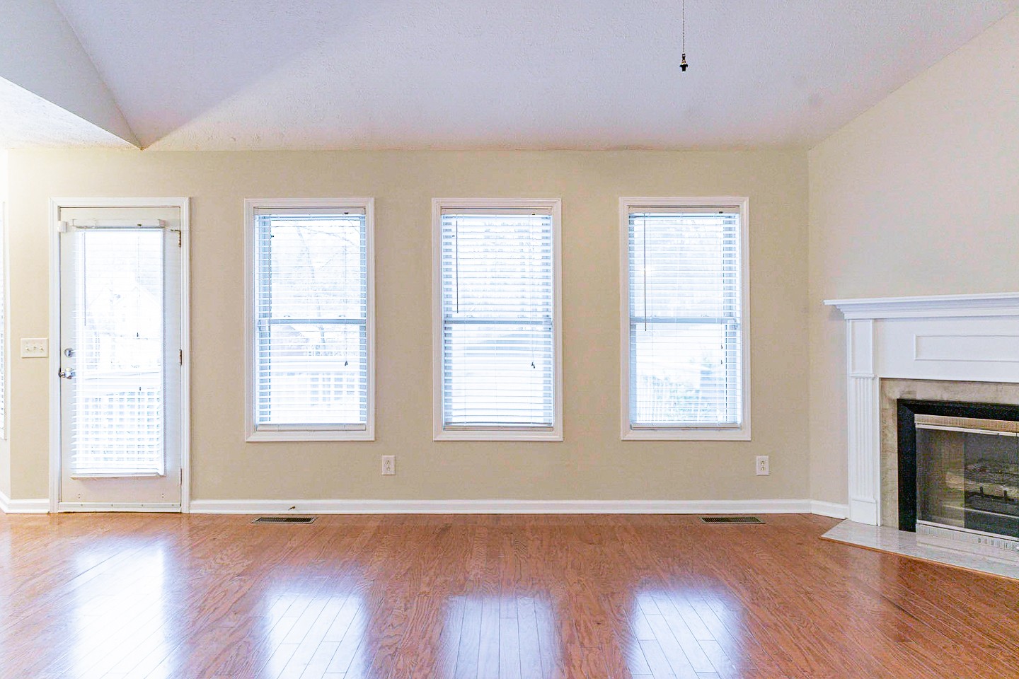 105 High Ridge Court Goodlettsville, TN 37072 - Photo 12 of 31 an empty room with wooden floor fireplace and windows