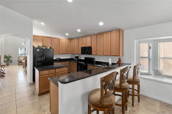 a kitchen with stainless steel appliances granite countertop a stove a sink a microwave a dining table and chairs