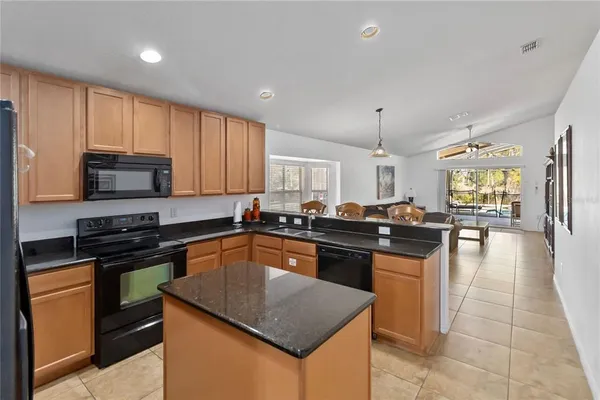 a kitchen with a stove a sink a counter top space and cabinets