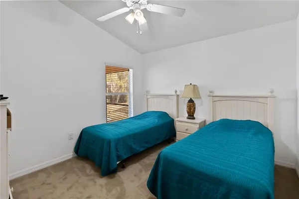 a bedroom with two beds and a chandelier