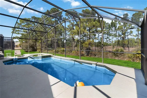a view of a swimming pool with a yard and sitting area