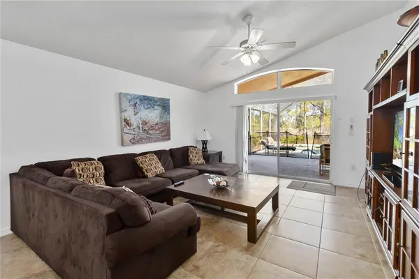 a living room with furniture a dining table and a flat screen tv