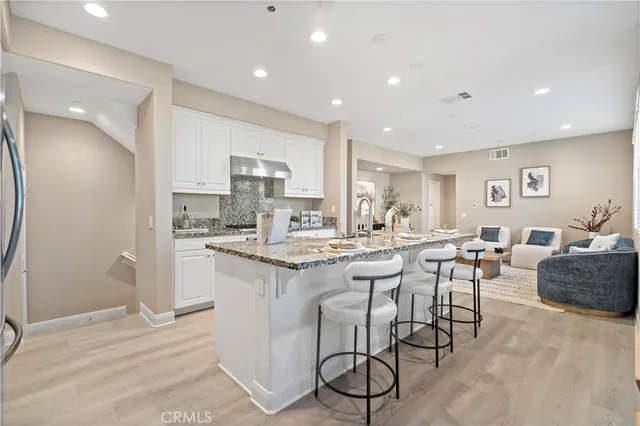 a kitchen with stainless steel appliances kitchen island granite countertop a sink and cabinets