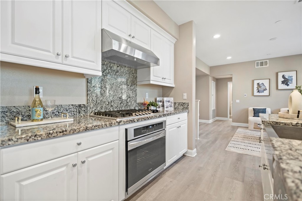 7459 Solstice Place Rancho Cucamonga, CA 91739 - Photo 12 of 57 a kitchen with stainless steel appliances granite countertop a stove and white cabinets