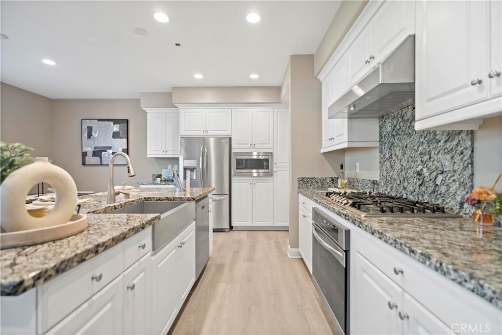 7459 Solstice Place Rancho Cucamonga, CA 91739 - Photo 16 of 57 a large kitchen with stainless steel appliances granite countertop a stove a sink and a refrigerator