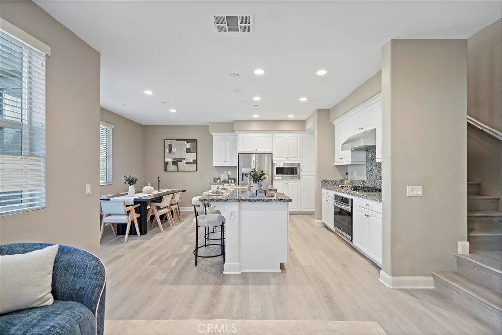 7459 Solstice Place Rancho Cucamonga, CA 91739 - Photo 22 of 57 a living room with stainless steel appliances furniture and a kitchen view