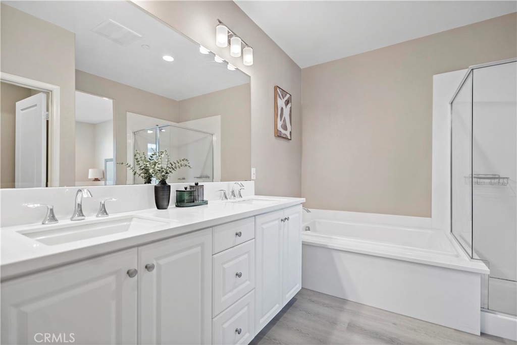 7459 Solstice Place Rancho Cucamonga, CA 91739 - Photo 33 of 57 a bathroom with a double vanity sink a toilet a mirror and shower