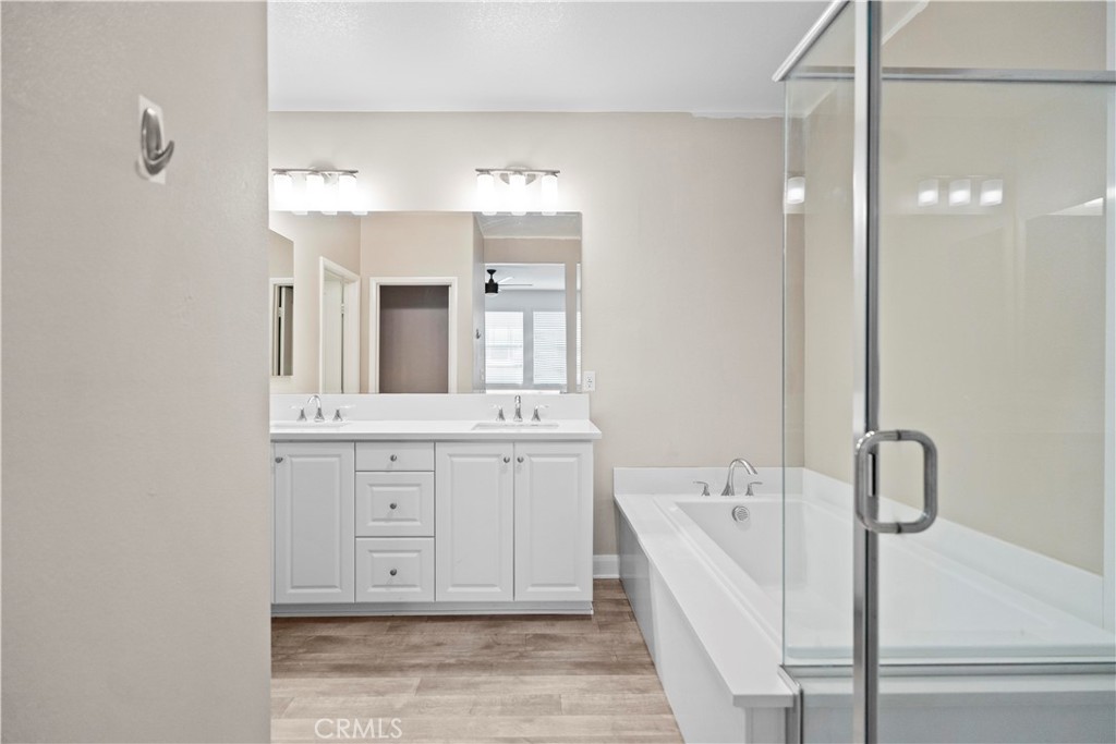 7459 Solstice Place Rancho Cucamonga, CA 91739 - Photo 47 of 57 a bathroom with a double vanity sink a mirror and a bathtub