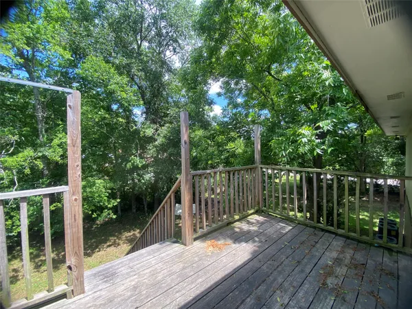 a balcony with wooden floor and fence