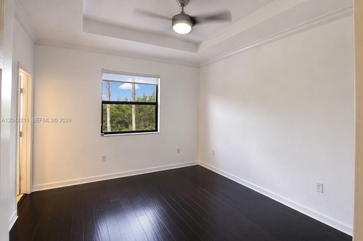 8954 West 35th Way Hialeah, FL 33018 - Photo 14 of 24 an empty room with wooden floor and windows