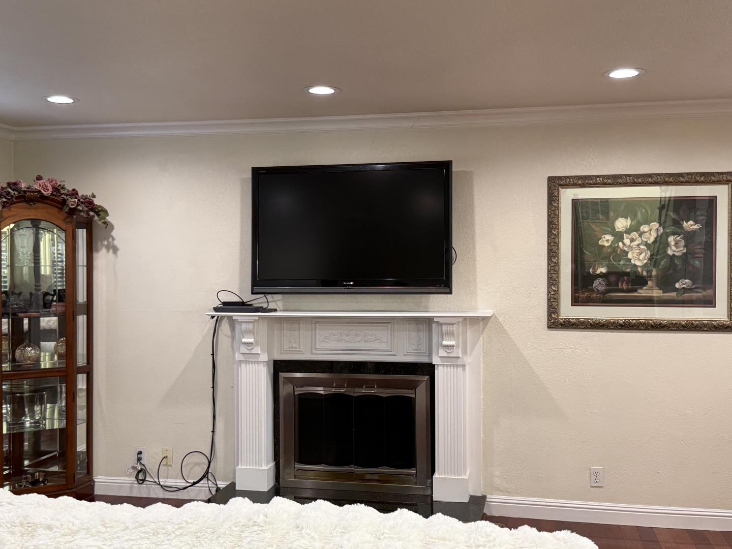 5736 Silver Leaf Road San Jose, CA 95138 - Photo 8 of 42 a living room with a fireplace and a flat screen tv