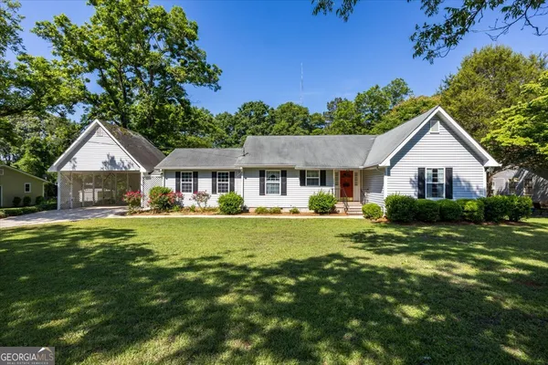 a front view of a house with yard and green space