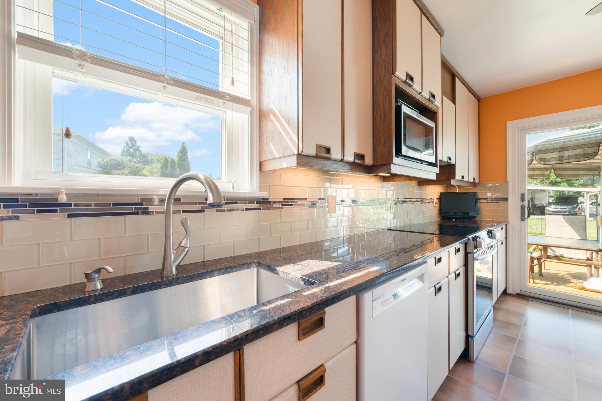 410 Crum Lynne Road Ridley Park, PA 19078 - Photo 15 of 43 a kitchen with granite countertop a sink and a wooden floor
