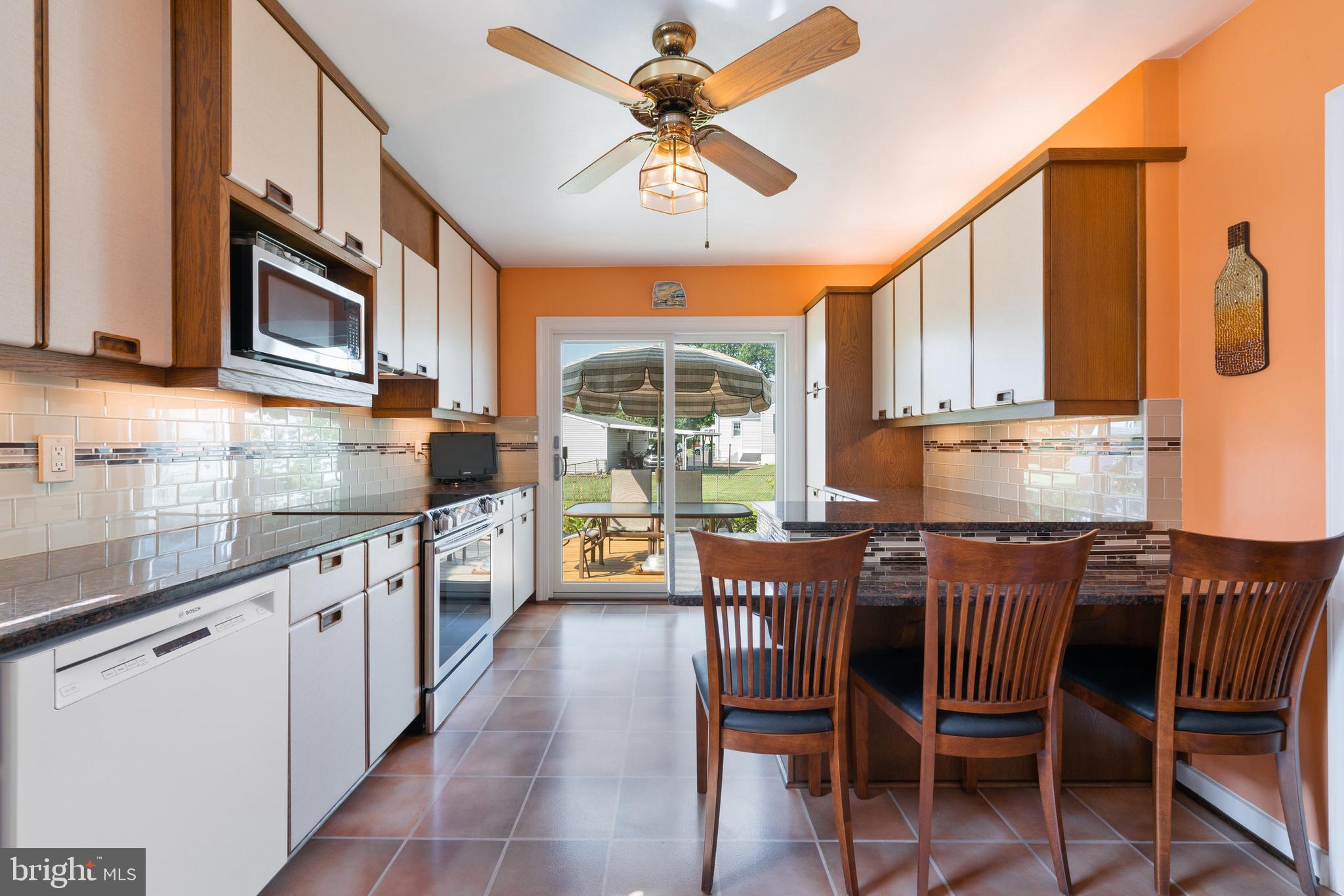 410 Crum Lynne Road Ridley Park, PA 19078 - Photo 5 of 43 a kitchen with stainless steel appliances granite countertop a stove top oven a sink dishwasher a dining table and chairs with wooden floor