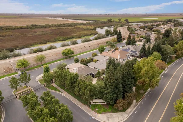 an aerial view of a house with a yard and large trees