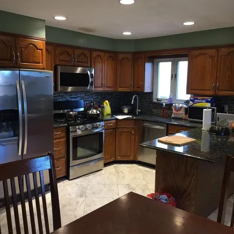 a kitchen with stainless steel appliances granite countertop a stove a sink and a microwave