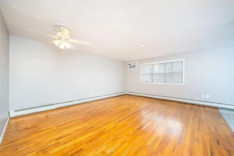 a view of a room with wooden floor and a window