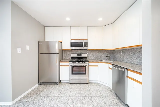 a kitchen with a refrigerator and a stove top oven