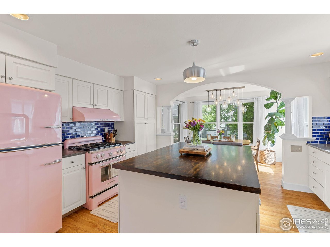 1133 Mapleton Avenue Boulder, CO 80304 - Photo 13 of 40 a kitchen with stainless steel appliances granite countertop a stove a refrigerator a sink dishwasher and white cabinets next to a window