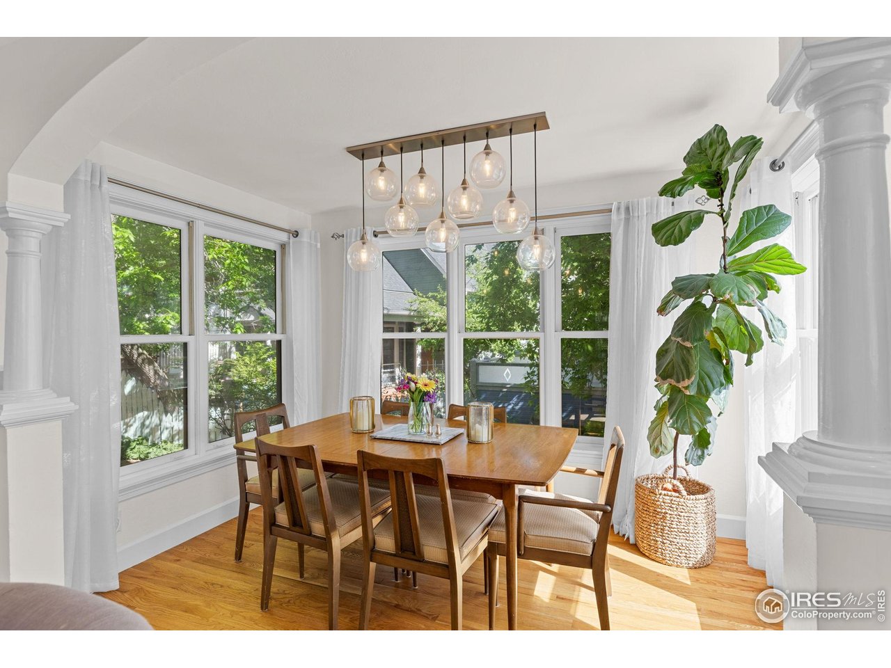 1133 Mapleton Avenue Boulder, CO 80304 - Photo 16 of 40 a dining room with furniture potted plants and wooden floor