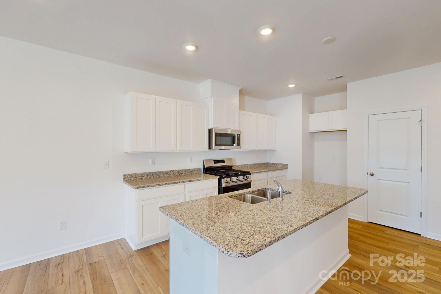 1129 Overbrook Place Wingate, NC 28174 - Photo 6 of 21 a kitchen with stainless steel appliances granite countertop a sink refrigerator and microwave
