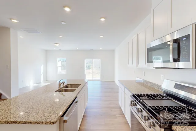 a kitchen with sink stove and cabinets