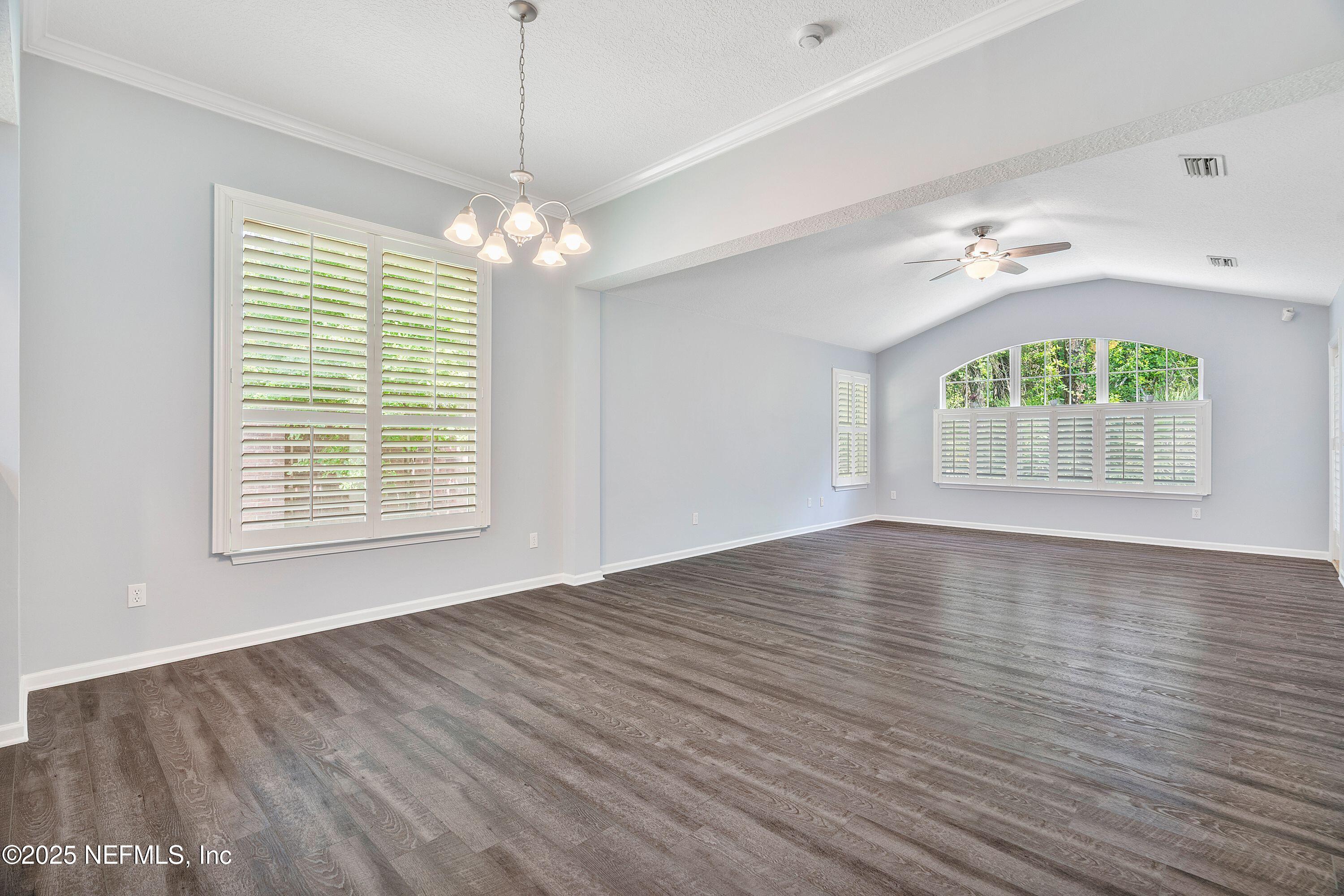 2120 Stone Creek Drive, Unit E Fleming Island, FL 32003 - Photo 14 of 66 a view of an empty room with a window and wooden floor