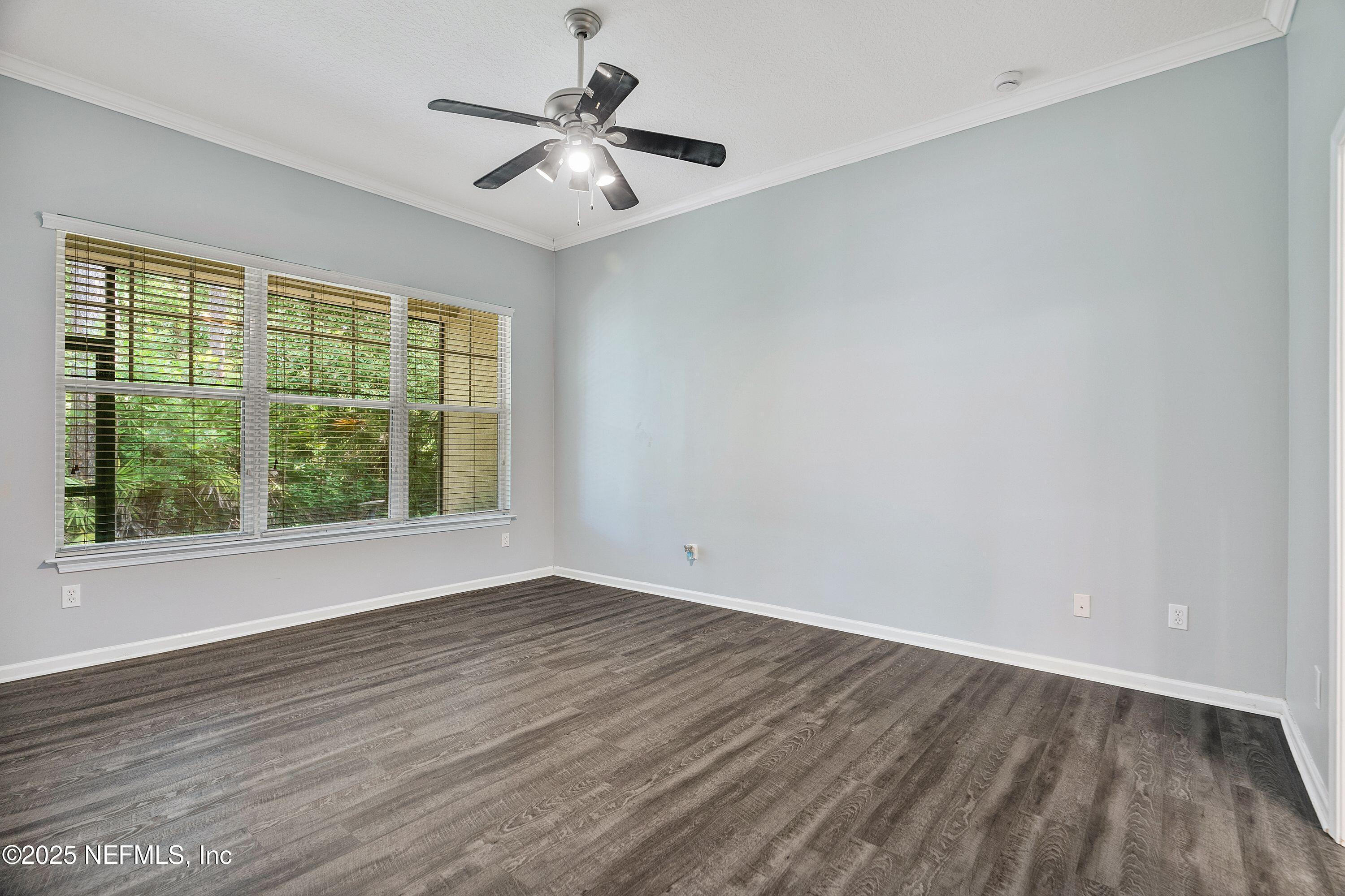 2120 Stone Creek Drive, Unit E Fleming Island, FL 32003 - Photo 19 of 66 a view of an empty room with wooden floor and a window