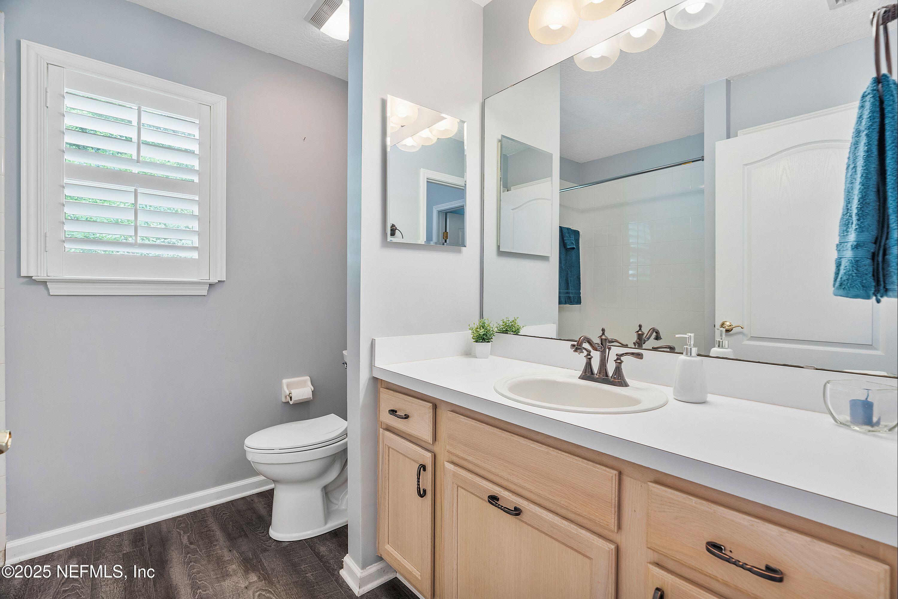 2120 Stone Creek Drive, Unit E Fleming Island, FL 32003 - Photo 25 of 66 a bathroom with a granite countertop toilet sink and mirror