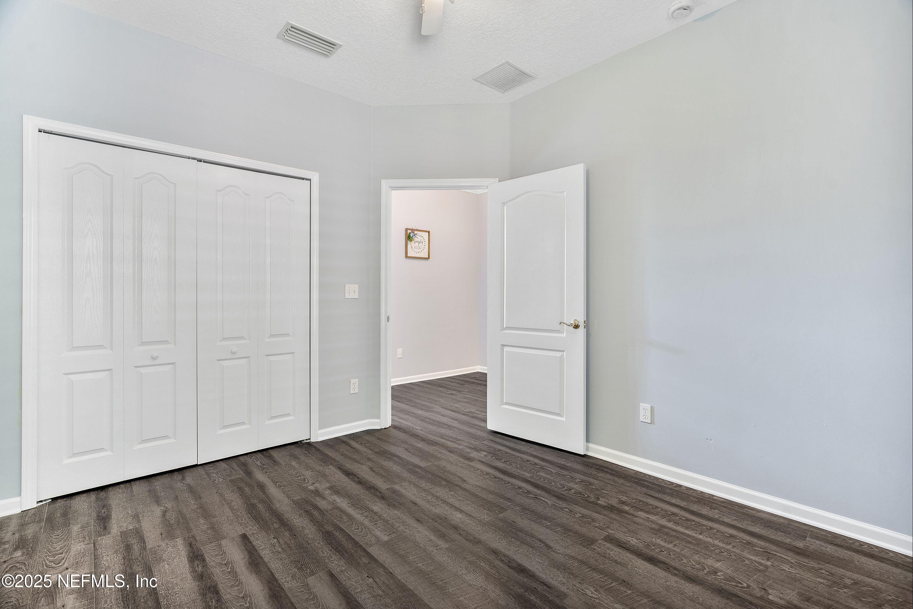 2120 Stone Creek Drive, Unit E Fleming Island, FL 32003 - Photo 27 of 66 a view of an empty room with closet and wooden floor