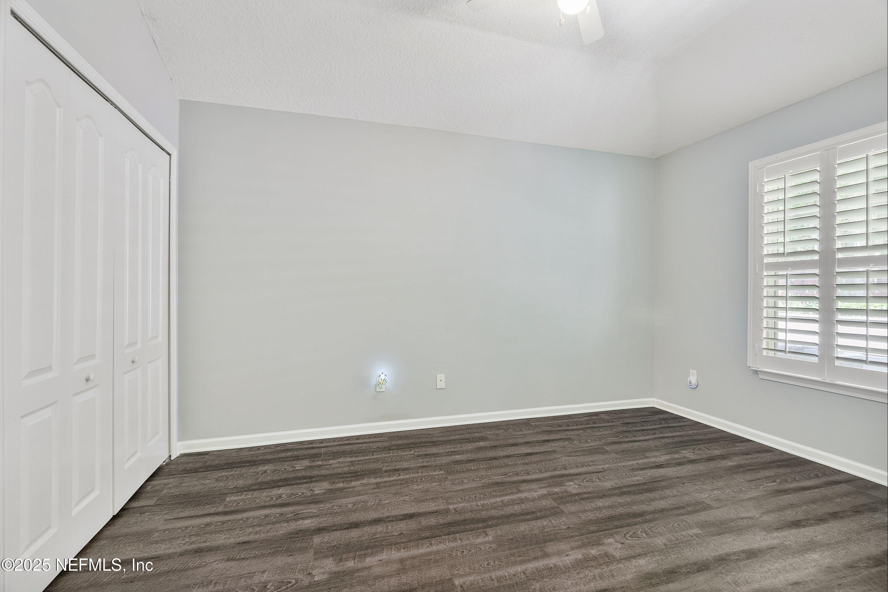 2120 Stone Creek Drive, Unit E Fleming Island, FL 32003 - Photo 28 of 66 a view of an empty room with wooden floor and a window