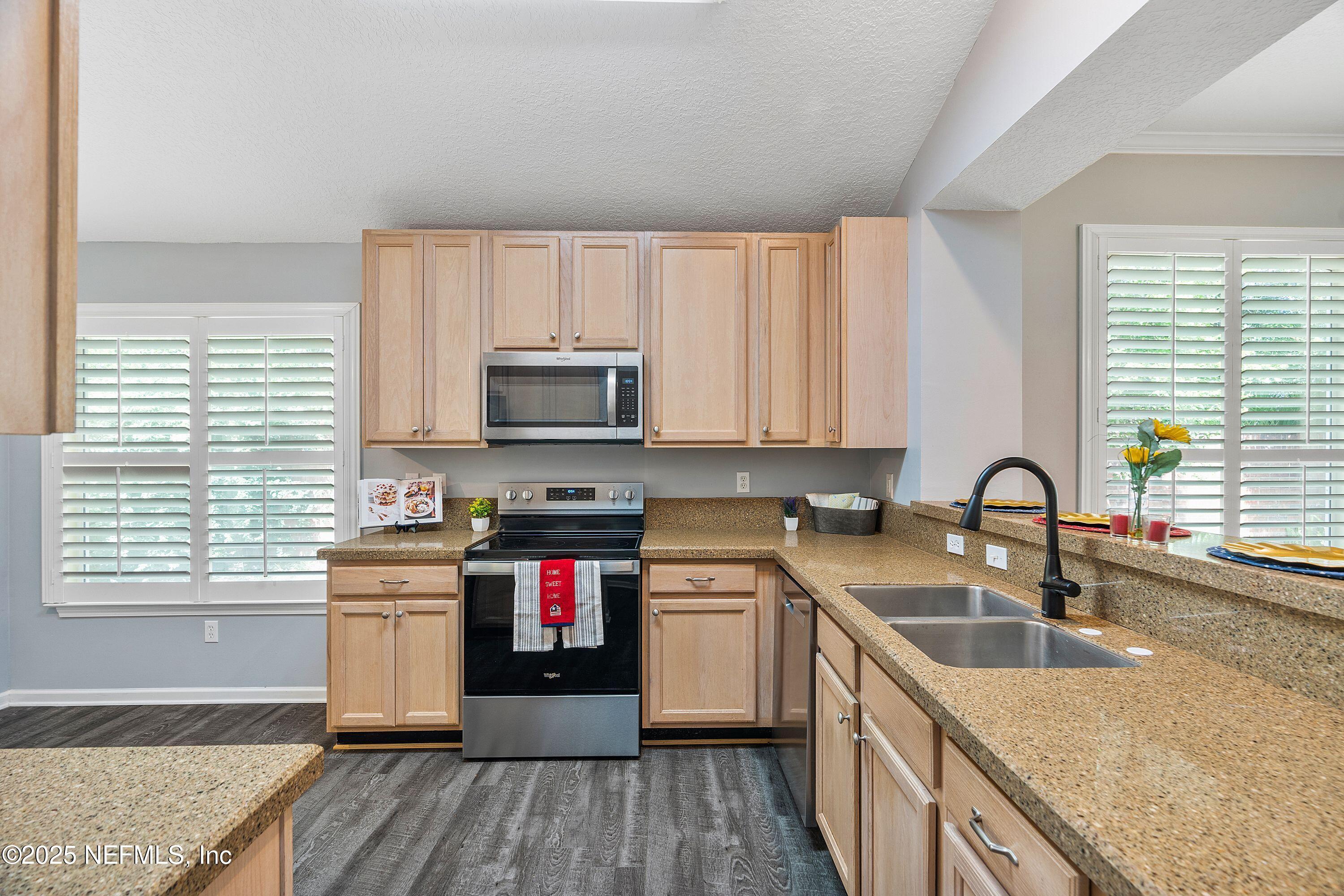 2120 Stone Creek Drive, Unit E Fleming Island, FL 32003 - Photo 3 of 66 a kitchen with granite countertop a sink wooden cabinets and stainless steel appliances