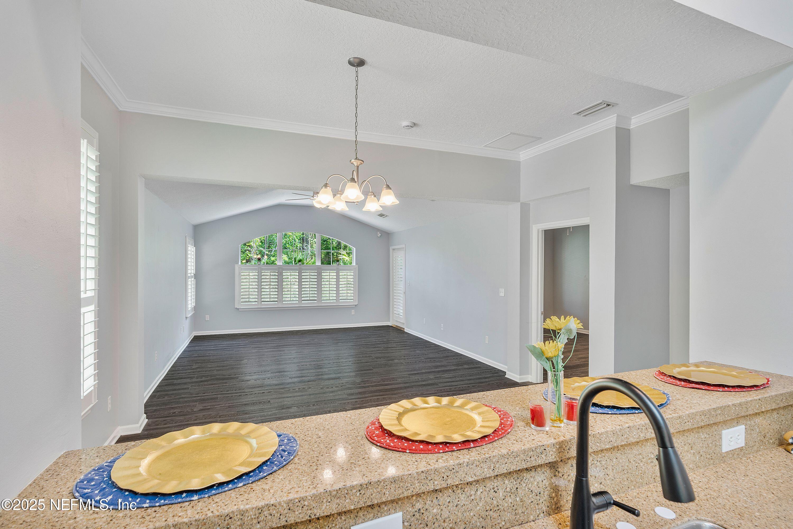 2120 Stone Creek Drive, Unit E Fleming Island, FL 32003 - Photo 4 of 66 a dining room with furniture a rug and a chandelier