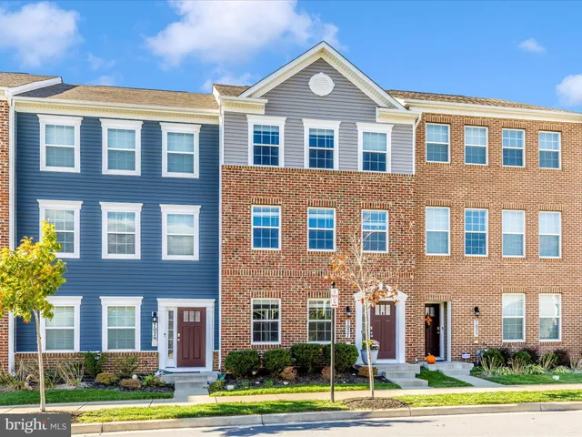 a kitchen with a table chairs refrigerator and wooden floor